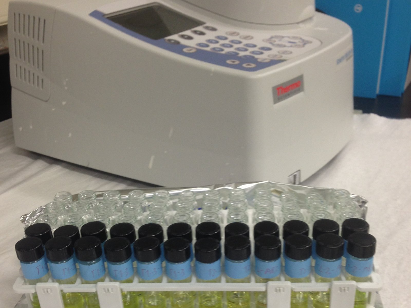 A Thermo Scientific spectrophotometer on a lab bench, with a rack of labelled vials of leaf pigment extracts