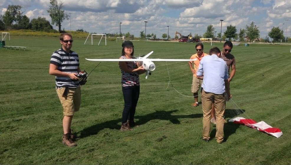 The team preparing a fixed-wing UAV for launch on a playing field