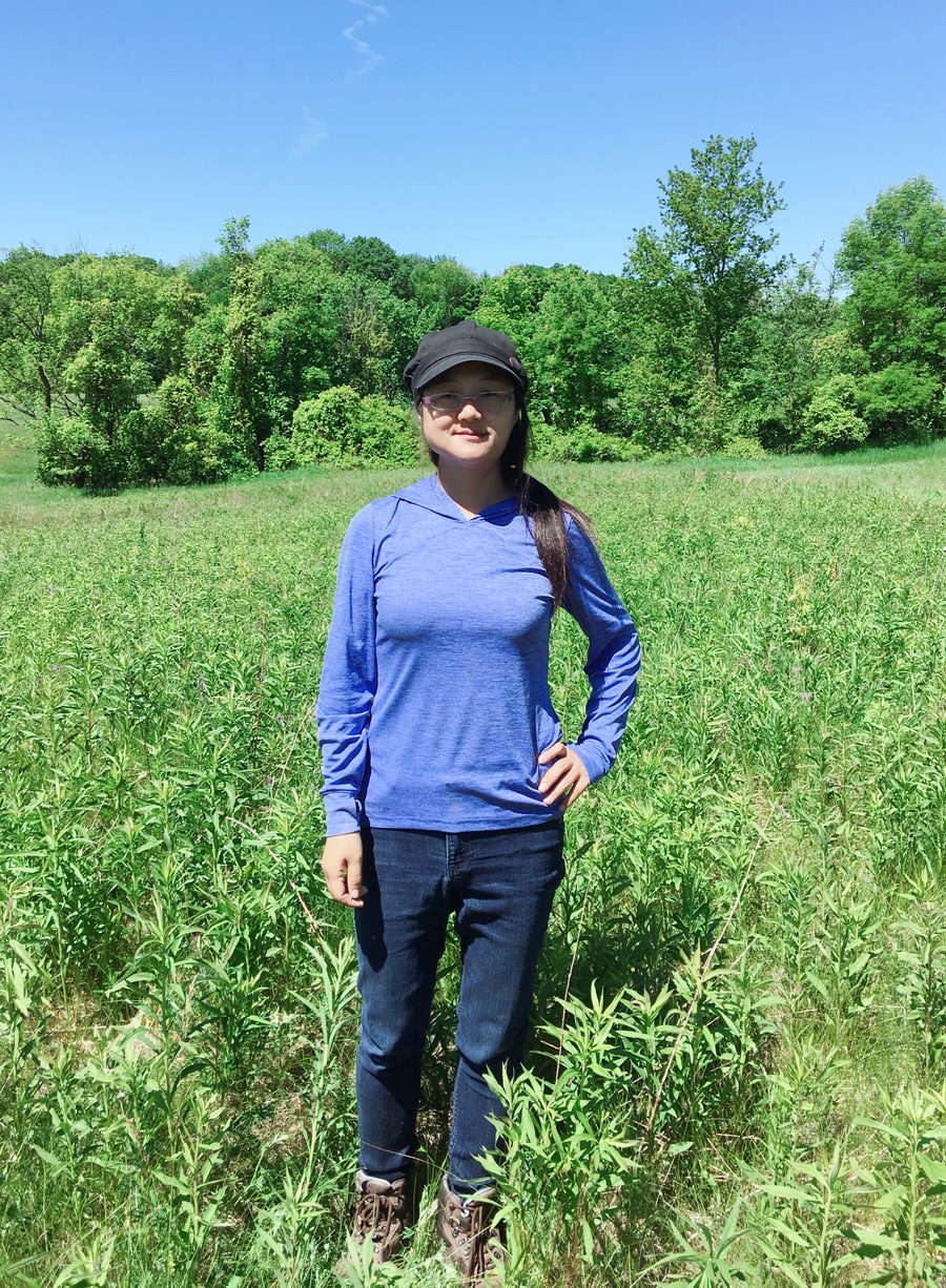 Prof. Yuhong He standing in a grassland field site
